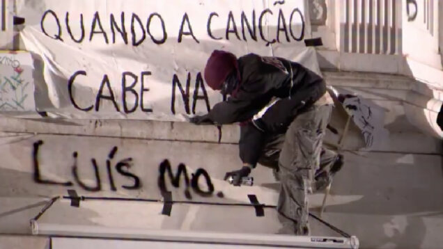 Homem de cara tapada é repreendido por manifestantes após escrever mensagem para Montenegro na estátua de D. Pedro IV